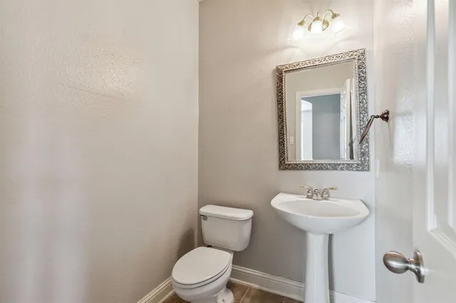 a bathroom with a toilet sink and mirror