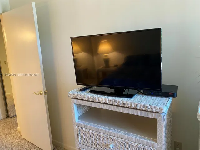 a living room with a flat screen tv and a floor to ceiling window