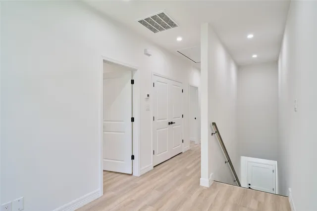 a view of a hallway with wooden floor and staircase