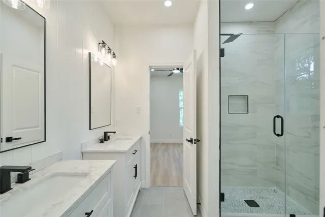 a bathroom with a double vanity sink mirror and shower