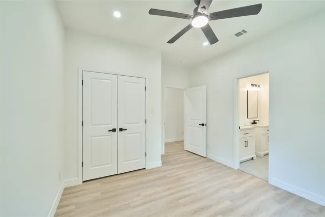 an empty room with closet and a ceiling fan