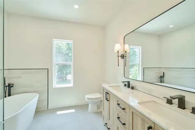 a bathroom with a double vanity sink toilet and shower