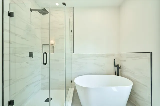 a white bath tub sitting next to a shower