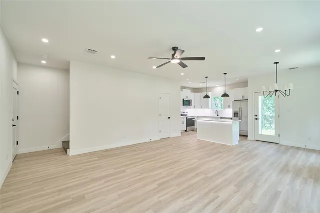 a view of a kitchen with kitchen island a sink stainless steel appliances and cabinets