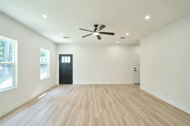 an empty room with fan and windows