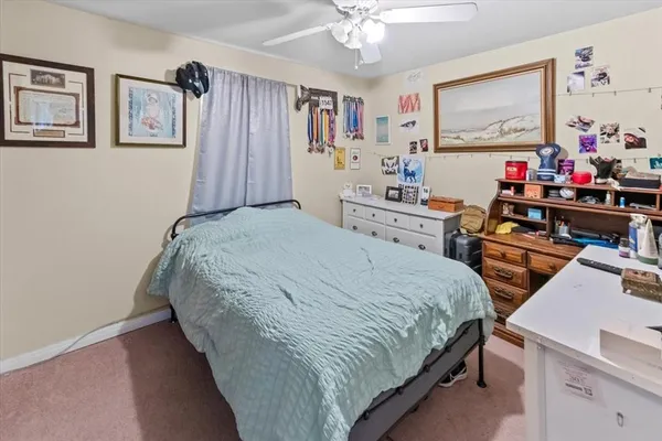 a bedroom with a bed and a flat tv screen on dresser