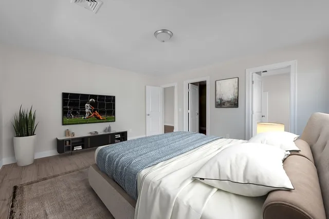 a bedroom with a bed and a flat screen tv