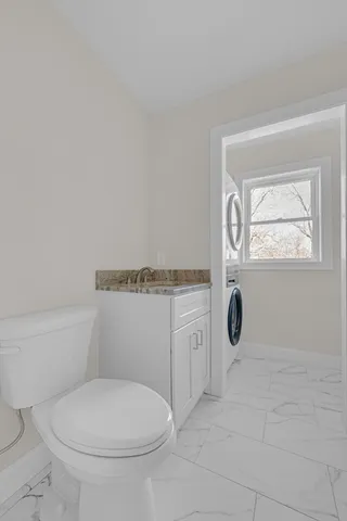 a bathroom with a toilet a sink and mirror