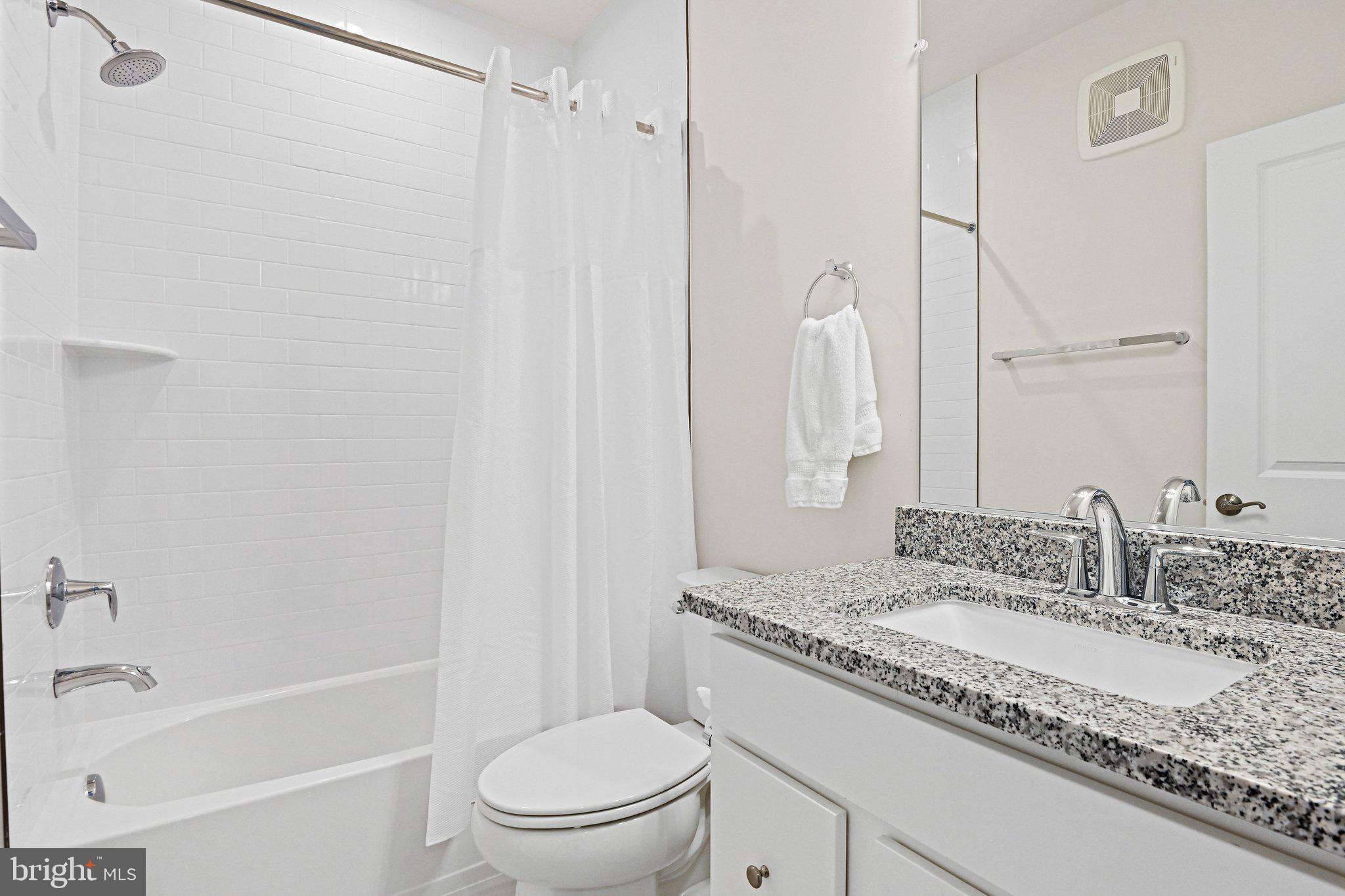 13556 Innovation Station Loop, Unit 15A Herndon, VA 20171 - Photo 12 of 28 a bathroom with a granite countertop sink a toilet and shower