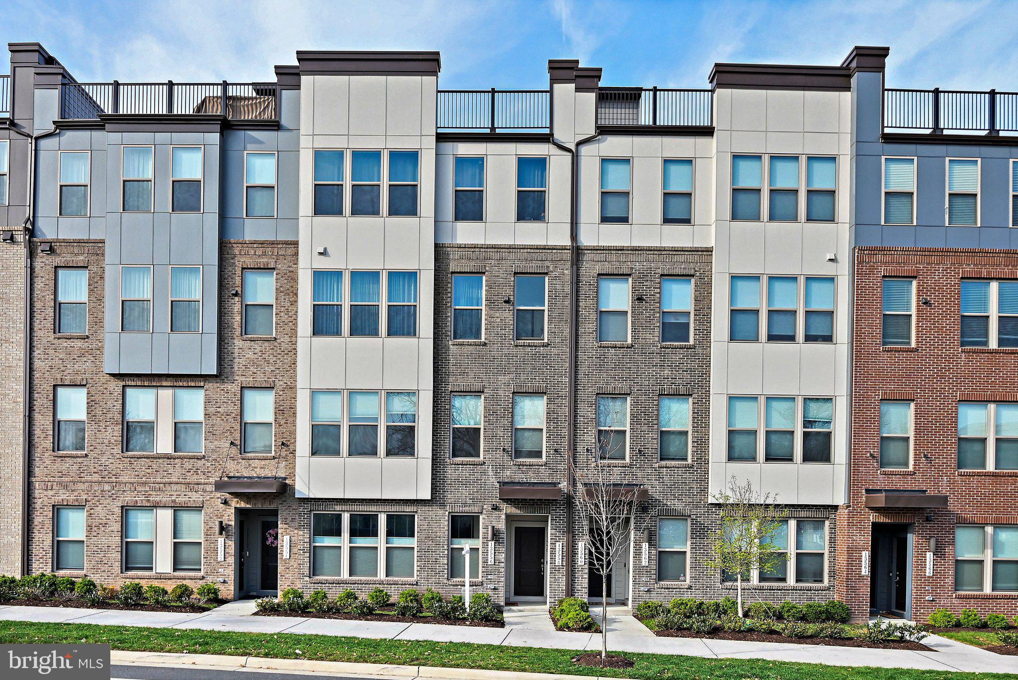 13556 Innovation Station Loop, Unit 15A Herndon, VA 20171 - Photo 23 of 28 a front view of a building with a yard
