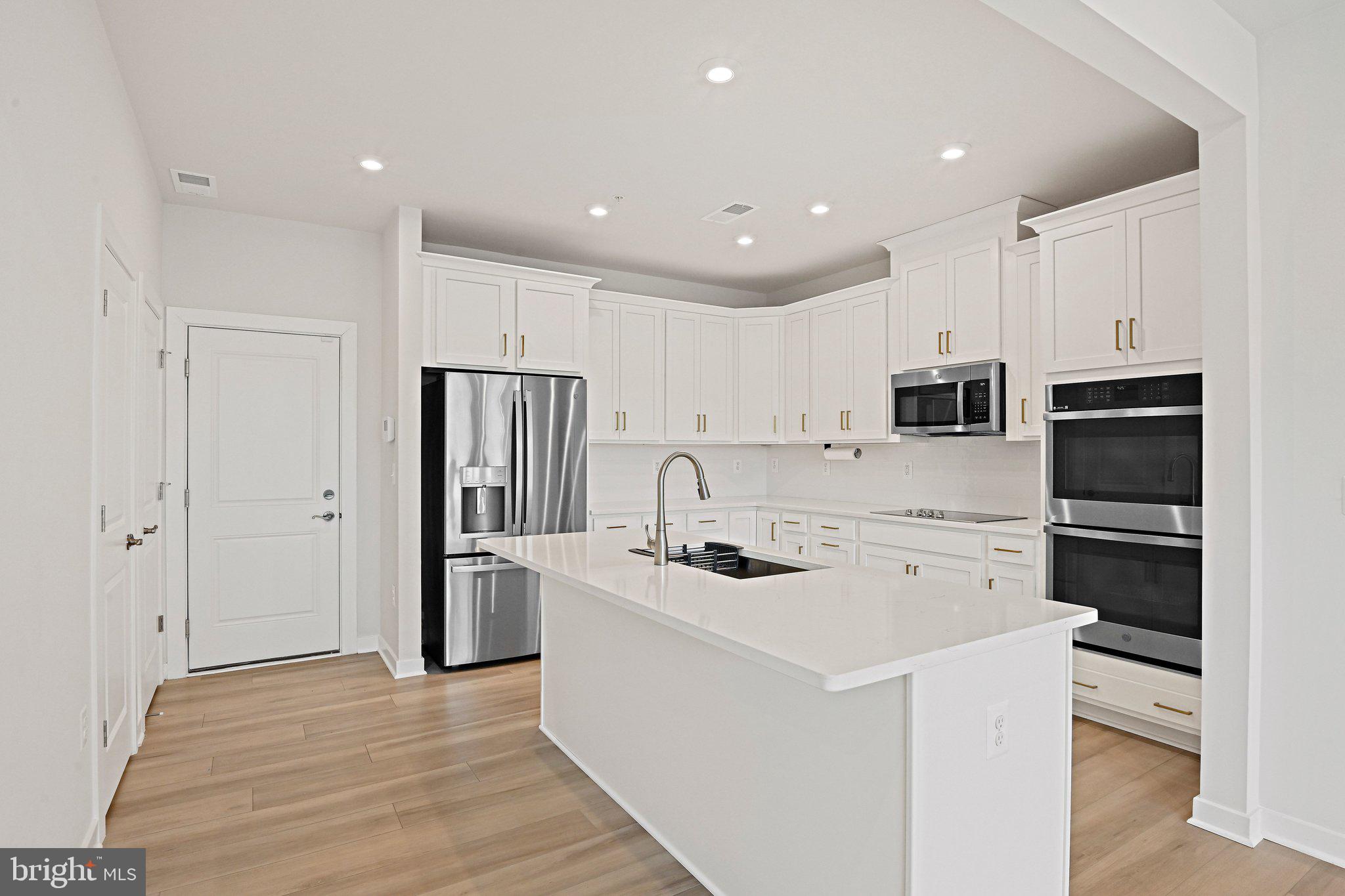 13556 Innovation Station Loop, Unit 15A Herndon, VA 20171 - Photo 3 of 28 a kitchen with stainless steel appliances a refrigerator stove microwave and cabinets