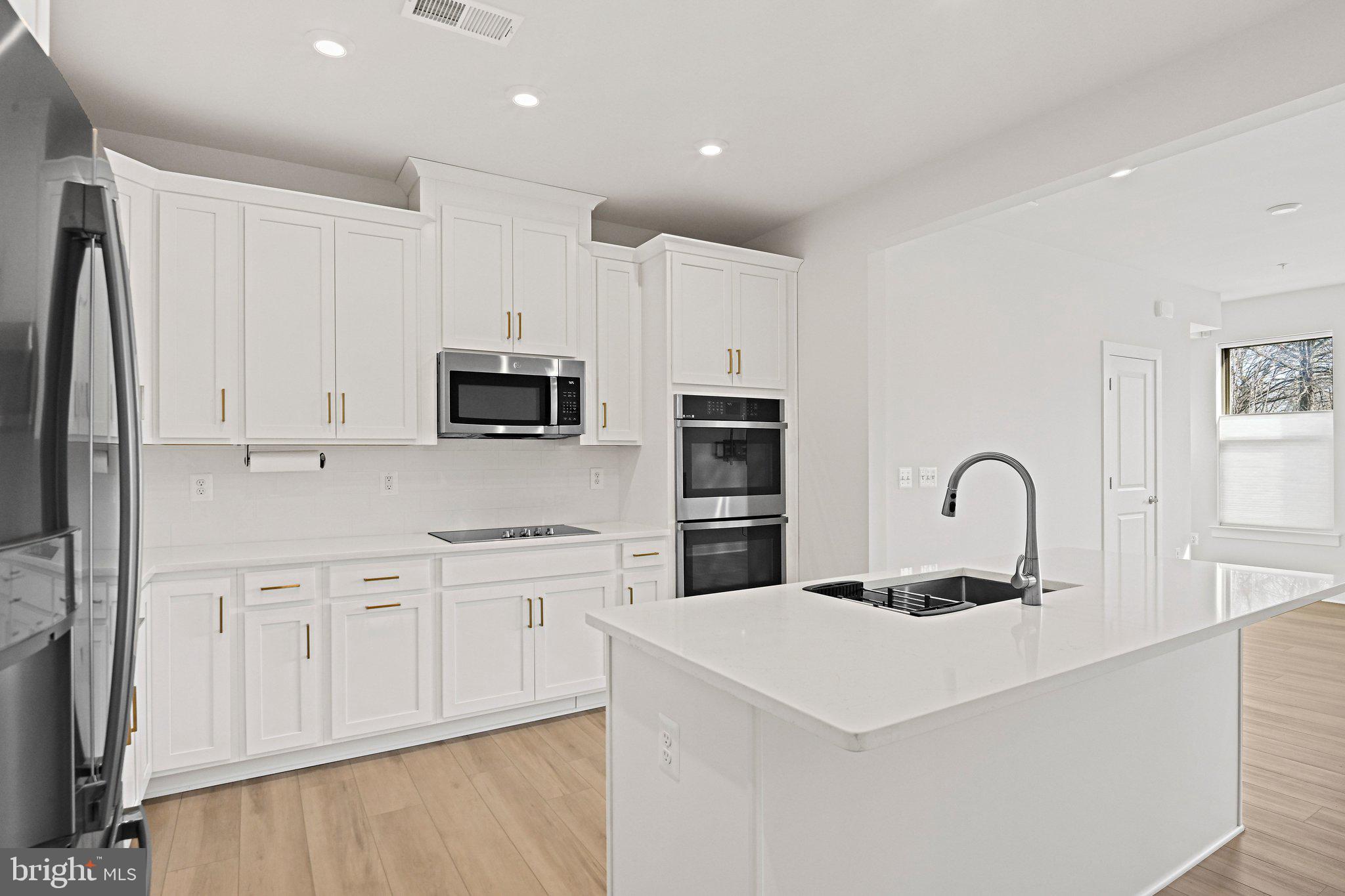 13556 Innovation Station Loop, Unit 15A Herndon, VA 20171 - Photo 4 of 28 a kitchen with white cabinets and stainless steel appliances