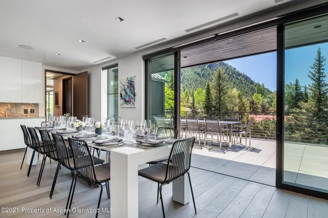 a view of a dining room with furniture large windows and wooden floor