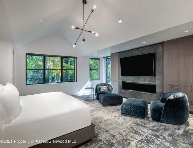 a bedroom with a bed a couch and a flat screen television