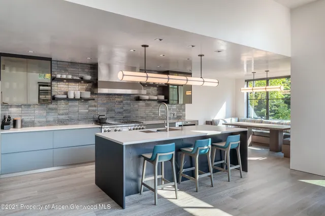 a kitchen with stainless steel appliances granite countertop a stove a sink a refrigerator and a dining table