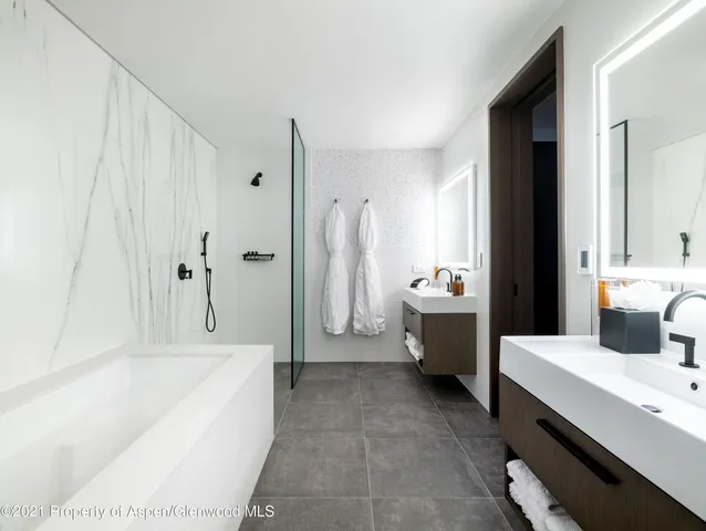 a bathroom with a tub a sink a mirror and a shower