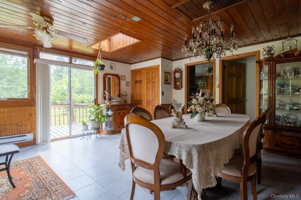 139 Haddock Road Monticello, NY 12701 - Photo 13 of 40 Dining area with a ceiling fan, wood ceiling, a chandelier, and baseboard heating