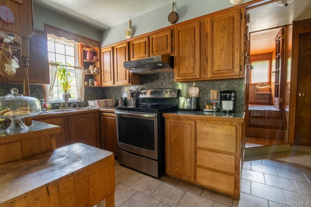 139 Haddock Road Monticello, NY 12701 - Photo 21 of 40 Kitchen featuring stainless steel electric stove, light tile patterned floors, healthy amount of natural light, and under cabinet range hood