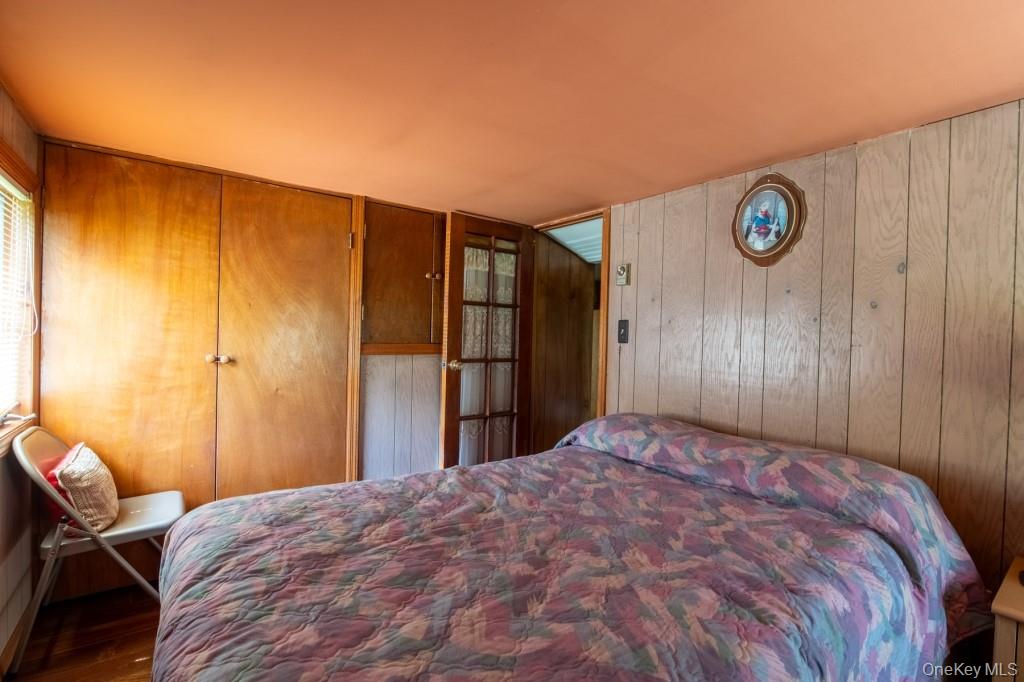 139 Haddock Road Monticello, NY 12701 - Photo 27 of 40 Bedroom with wooden walls and wood finished floors