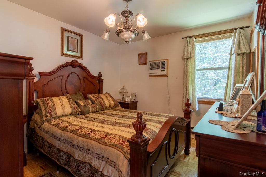 139 Haddock Road Monticello, NY 12701 - Photo 28 of 40 Bedroom with a chandelier and a wall mounted AC