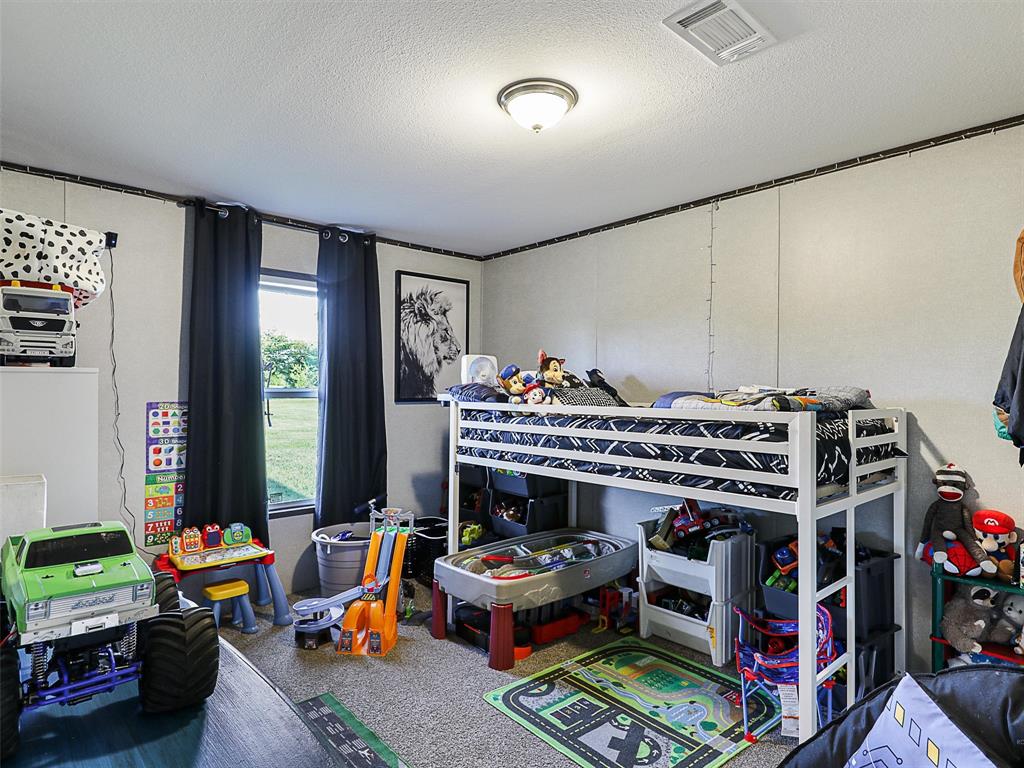 2149 Webb Smith Road Sherman, TX 75090 - Photo 18 of 39 a living room with lots of furniture and a baby crib
