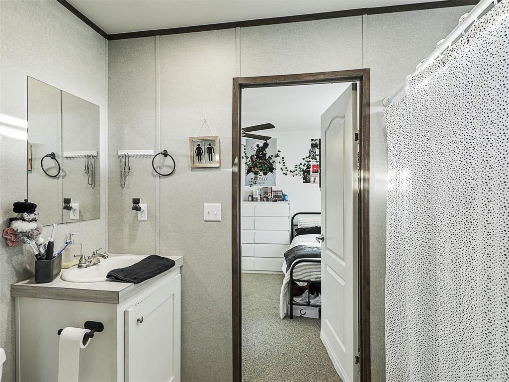 2149 Webb Smith Road Sherman, TX 75090 - Photo 20 of 39 a bathroom with a sink a mirror and shower