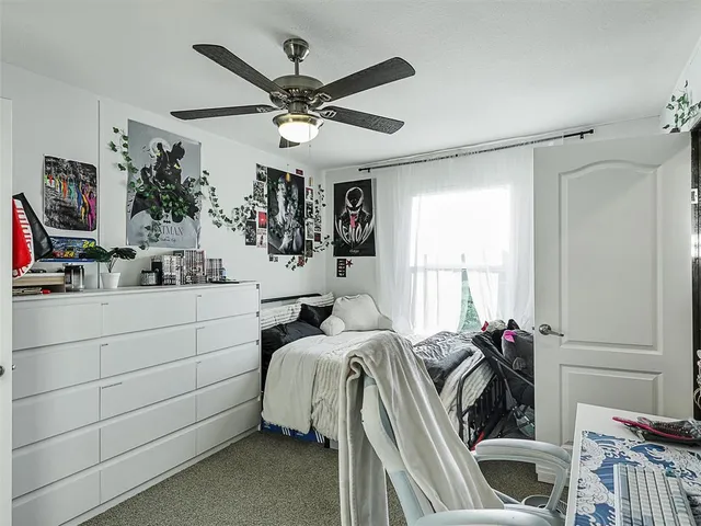 a bedroom with a bed a window and a flat screen tv