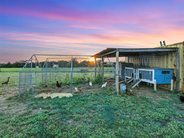 a view of a park with large trees and a wooden fence