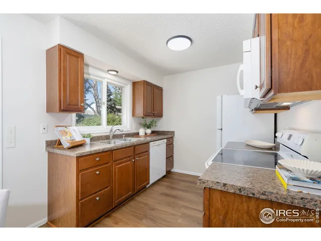 a kitchen with a sink a stove cabinets and a window