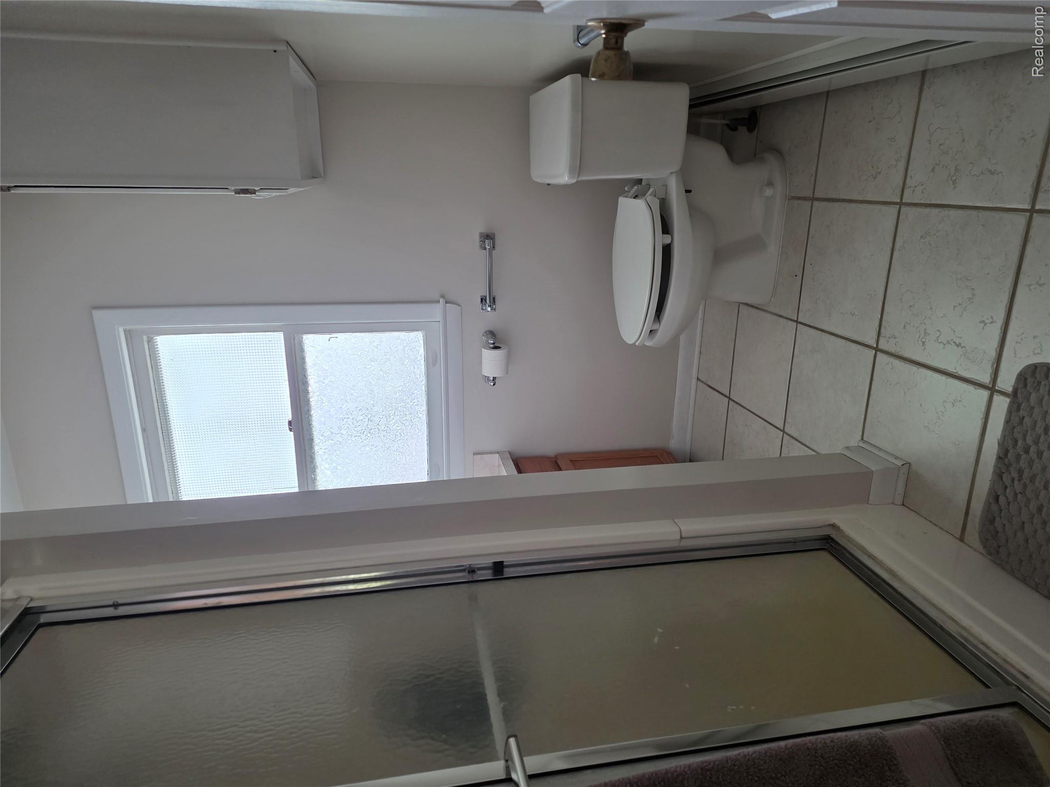 403 East Road Holly, MI 48442 - Photo 5 of 22 Bathroom featuring a stall shower, vanity, light tile patterned floors, and a baseboard radiator