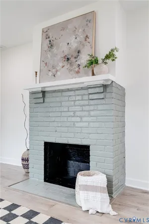 a living room with a fireplace and a potted plant