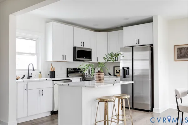 a kitchen with stainless steel appliances a refrigerator sink and microwave