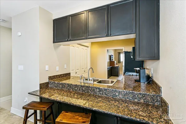 a kitchen with granite countertop a sink a stove and cabinets
