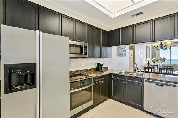 a kitchen with stainless steel appliances granite countertop a refrigerator and a microwave