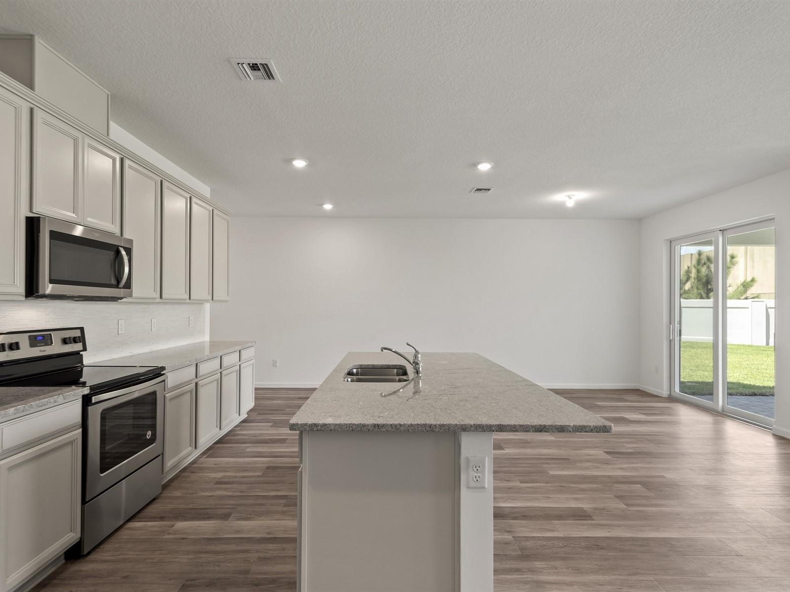 1927 Harding Street Lake Worth, FL 33460 - Photo 5 of 19 a kitchen with granite countertop a sink wooden floor and stainless steel appliances