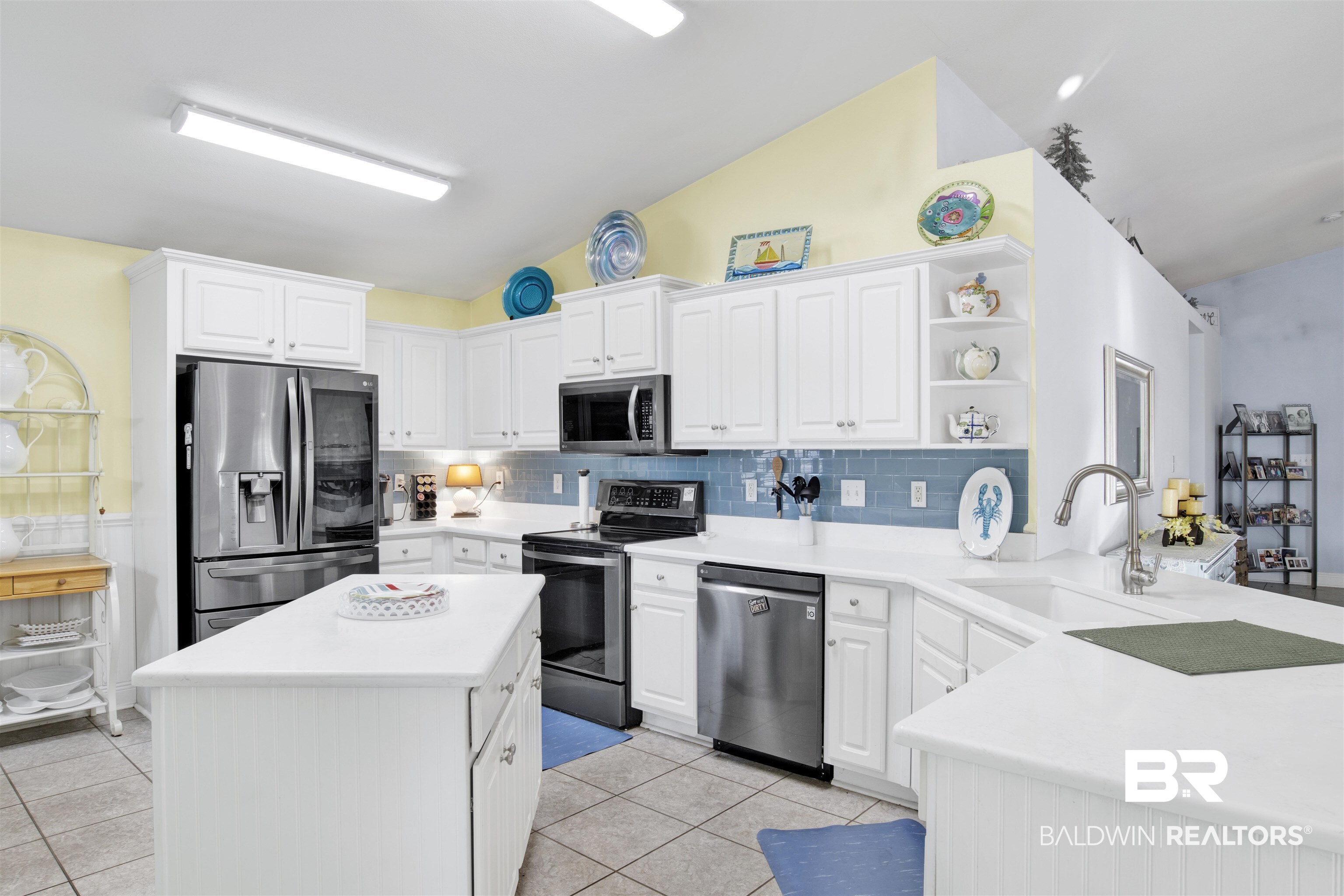 314 Blackfriars Street Fairhope, AL 36532 - Photo 11 of 25 Kitchen featuring white cabinetry, appliances with stainless steel finishes, sink, and lofted ceiling