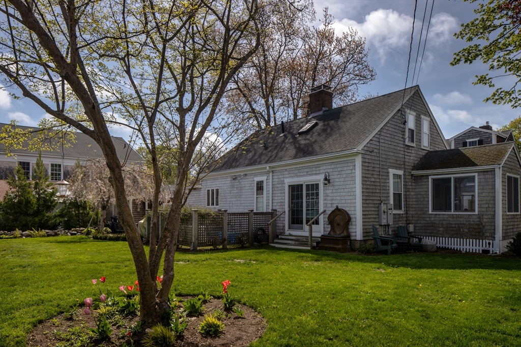 31 Main Street Marion, MA 02738 - Photo 15 of 29 a backyard of a house with barbeque oven and large trees