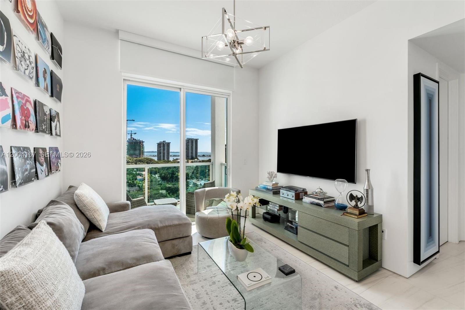 1723 Southwest 2nd Avenue, Unit PH2 Miami, FL 33129 - Photo 4 of 18 a living room with furniture a flat screen tv and a floor to ceiling window
