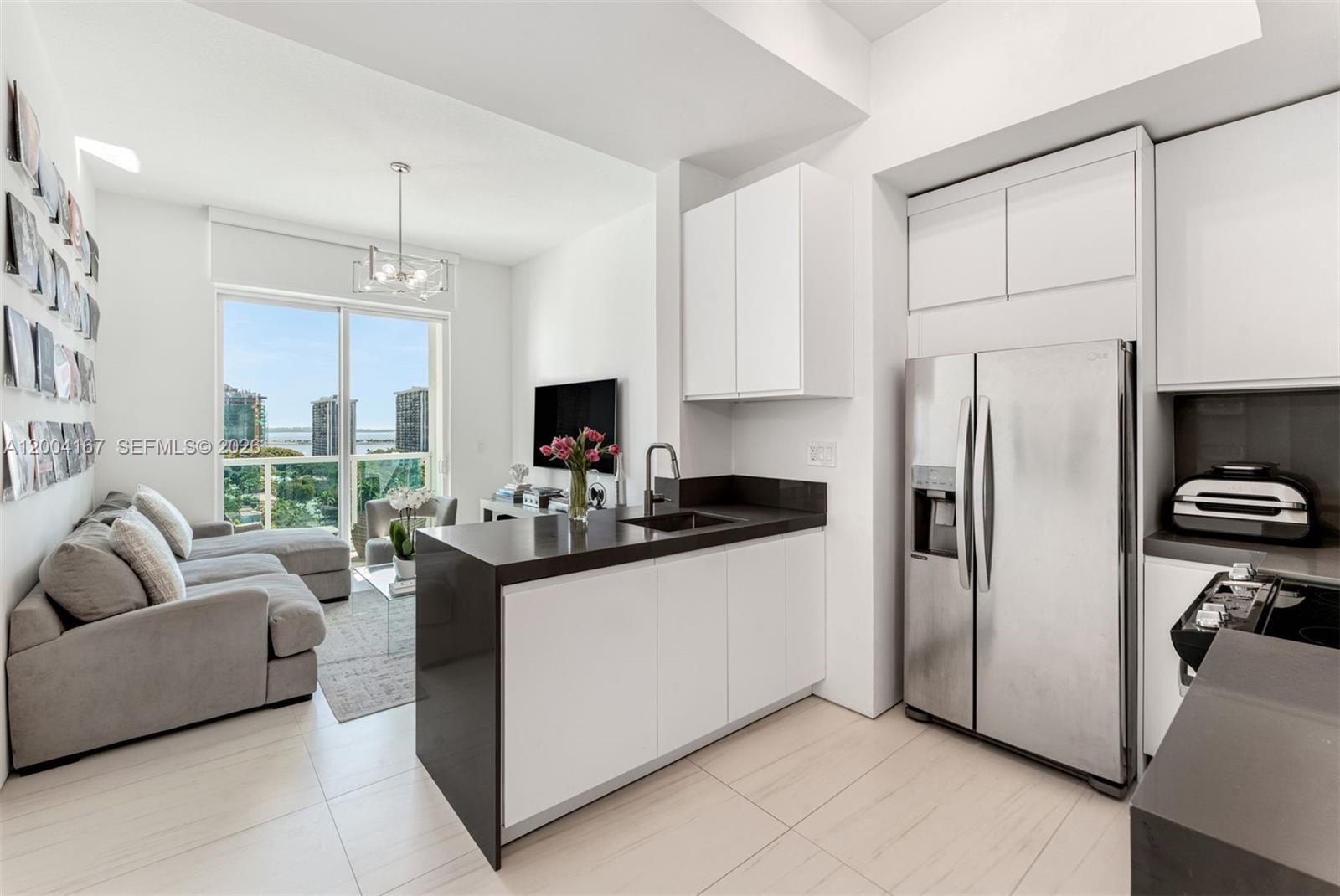 1723 Southwest 2nd Avenue, Unit PH2 Miami, FL 33129 - Photo 5 of 18 a kitchen with stainless steel appliances granite countertop a refrigerator and a stove top oven