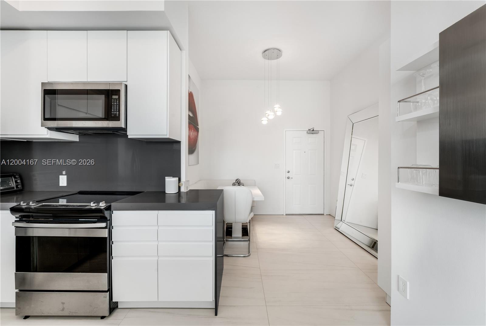 1723 Southwest 2nd Avenue, Unit PH2 Miami, FL 33129 - Photo 7 of 18 a kitchen with a stove and a microwave