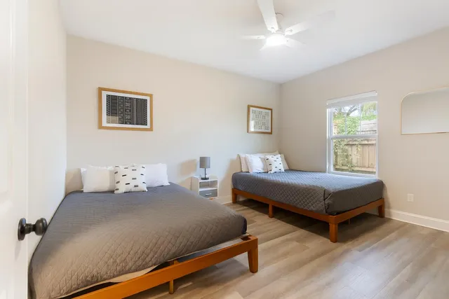 a bedroom with two beds and a night stand