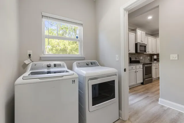 a view of washer and dryer with kitchen in the background