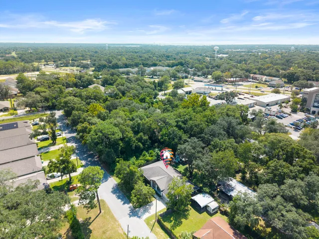 an aerial view of residential houses with outdoor space and trees