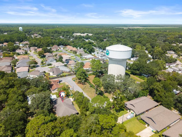 an aerial view of residential houses with outdoor space and trees