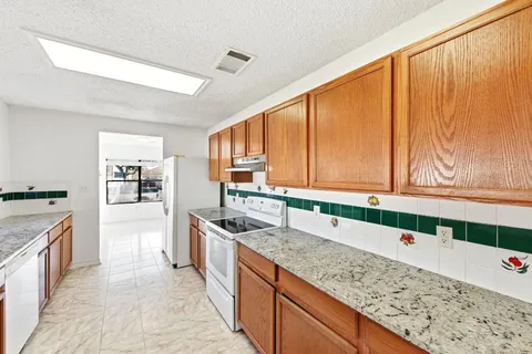 a kitchen with stainless steel appliances granite countertop a sink and a stove