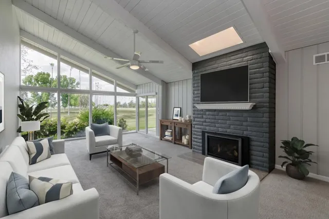 a living room with furniture fireplace and floor to ceiling windows
