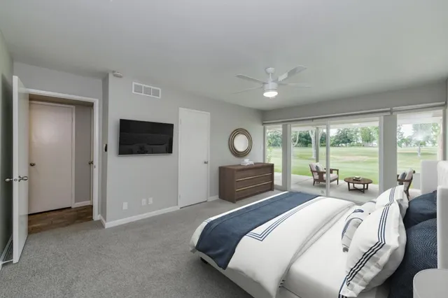 a bedroom with a bed and a large window with outer view