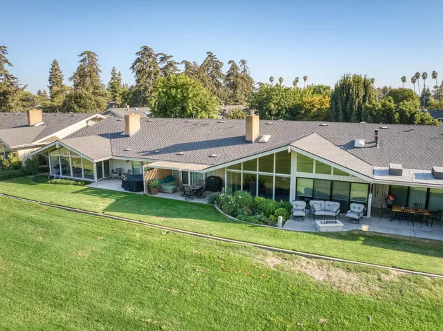 a view of a house with a big yard and potted plants