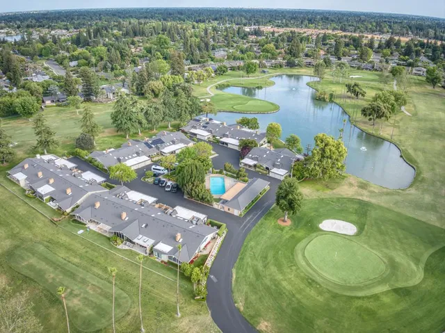 a swimming pool with trees in the background and a lake view