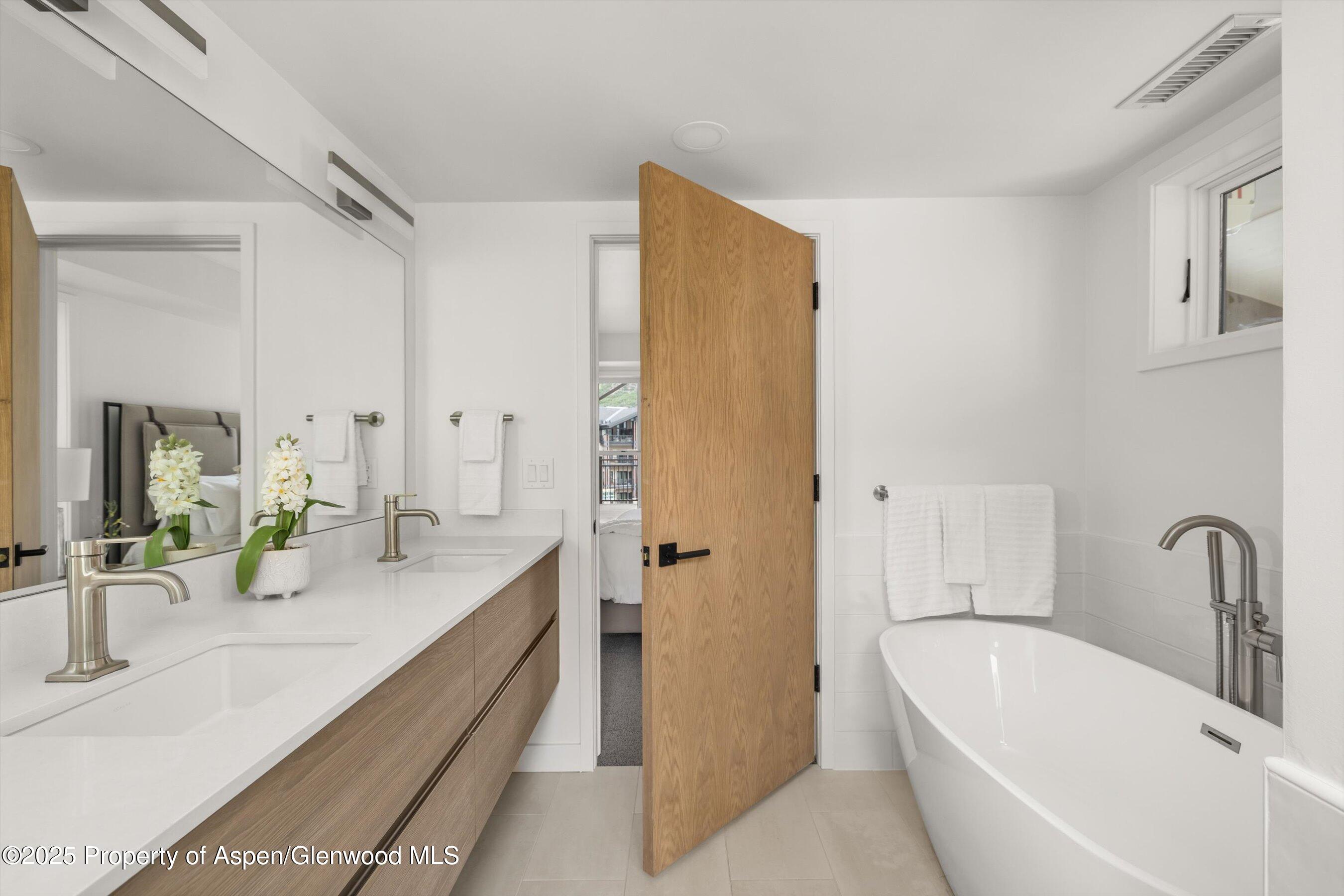 360 Wood Road, Unit 504 Snowmass Village, CO 81615 - Photo 16 of 22 a bathroom with a tub sink and mirror